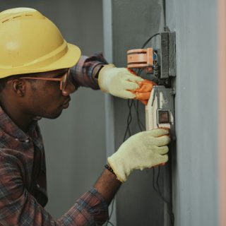 A young electrician in a hard hat working on wiring