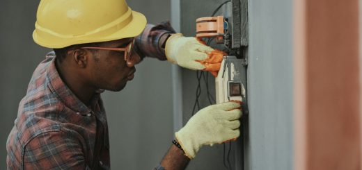 A young electrician in a hard hat working on wiring