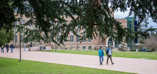Students walking along a path past a campus building