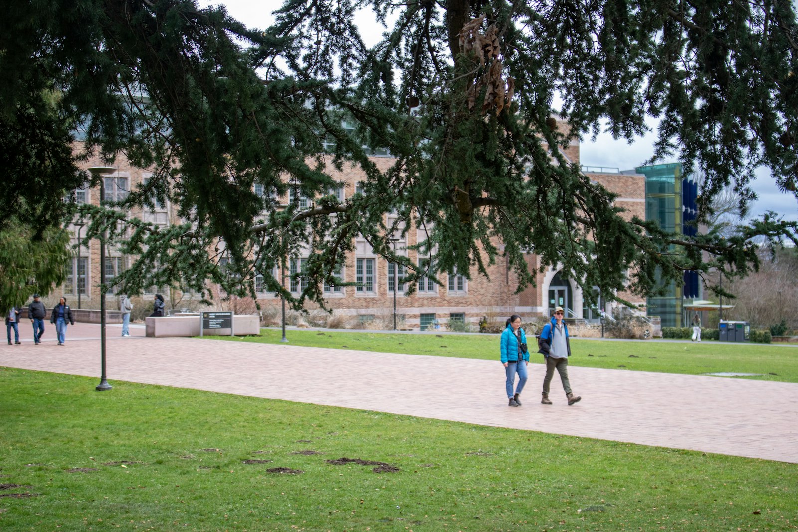 Students walking along a path past a campus building