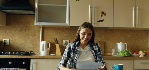 A woman reading study notes at a kitchen table with a cup of coffee