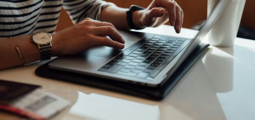 Hands typing on a laptop at a desk