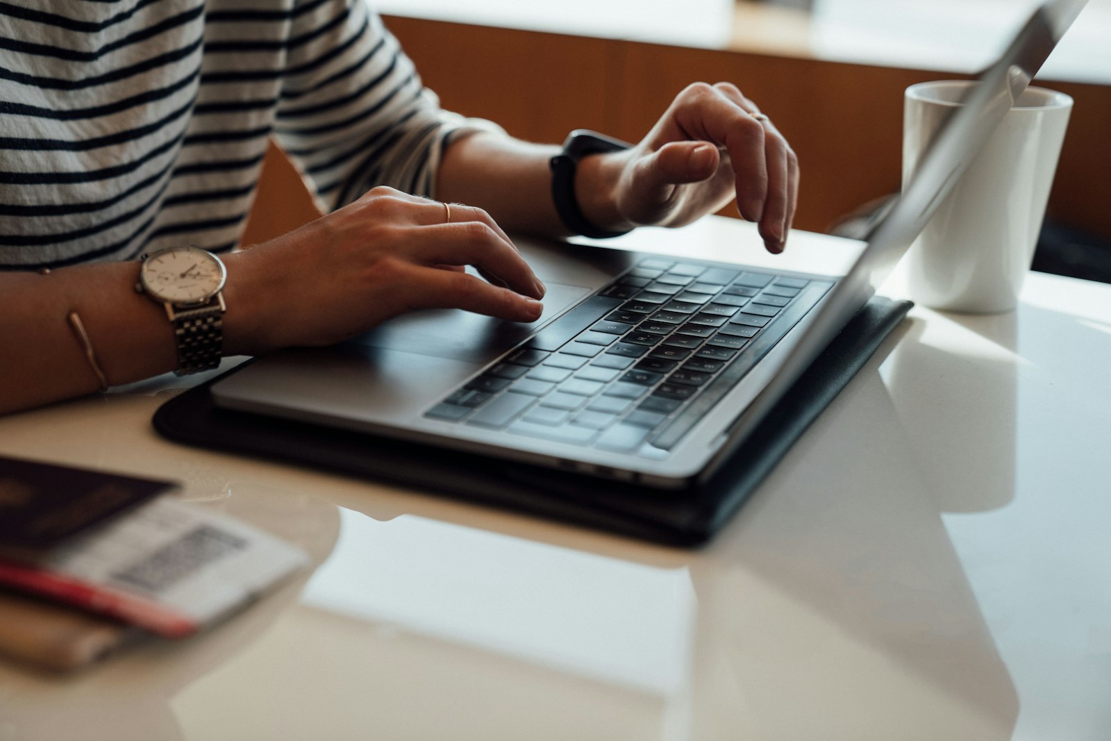 Hands typing on a laptop at a desk